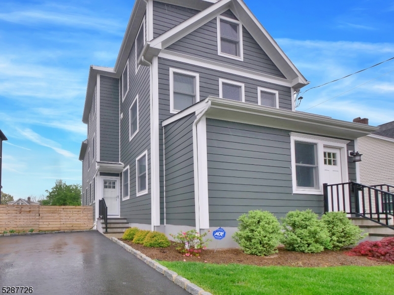 Front Welcome to this beautifully updated, multi-story residence featuring striking gray siding, crisp white trim, and a freshly manicured front lawn with tasteful landscaping.
