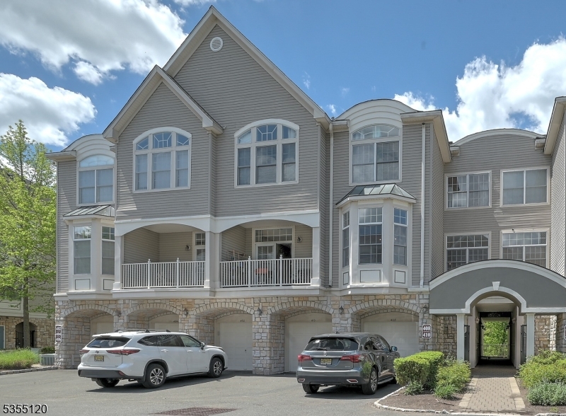 Elegant multi-level townhome with a private balcony, arched windows, and direct-entry garage in a beautifully maintained community