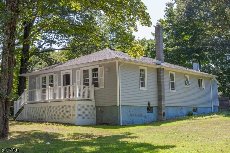 Vinyl siding, hip roof, 2-car wide driveway, large flat green lawn.