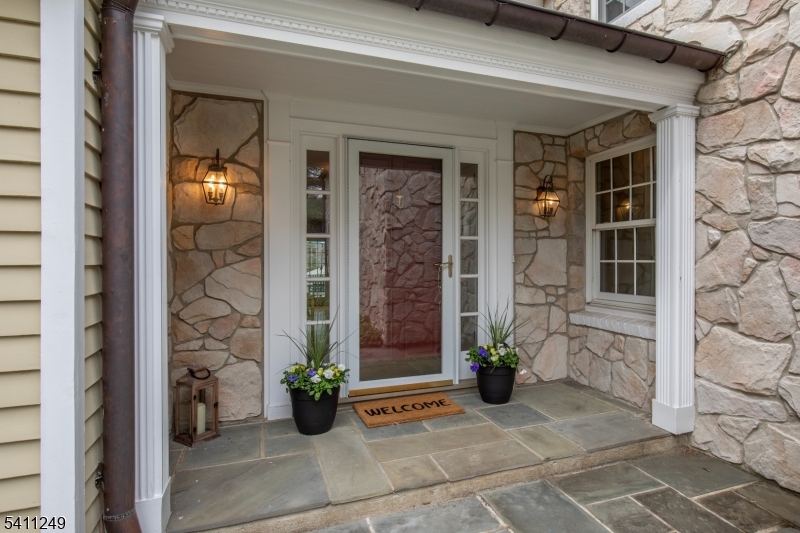 Front Elevation Bluestone walkway, stone framed porch and front door with sidelights