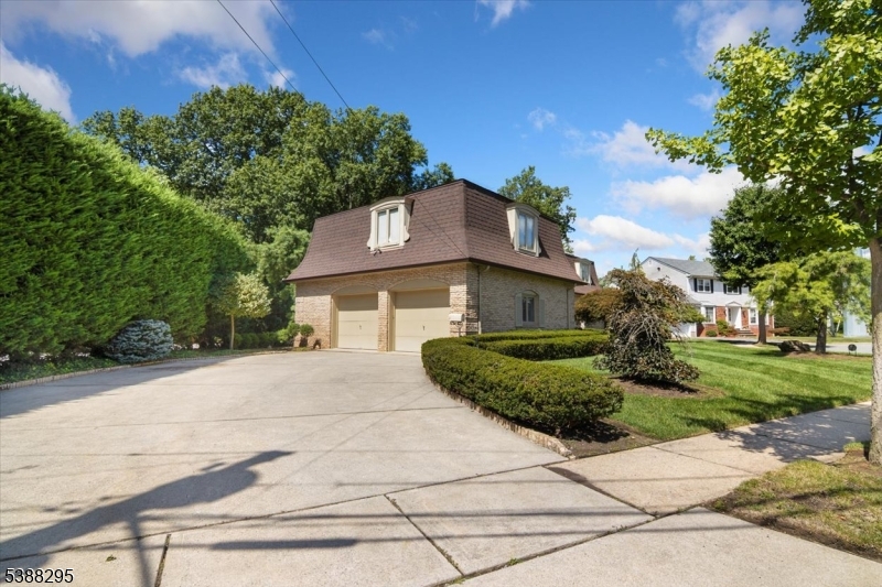 Front Generous driveway that flows into an oversized attached 2 car garage, providing ample space for vehicles and additional storage